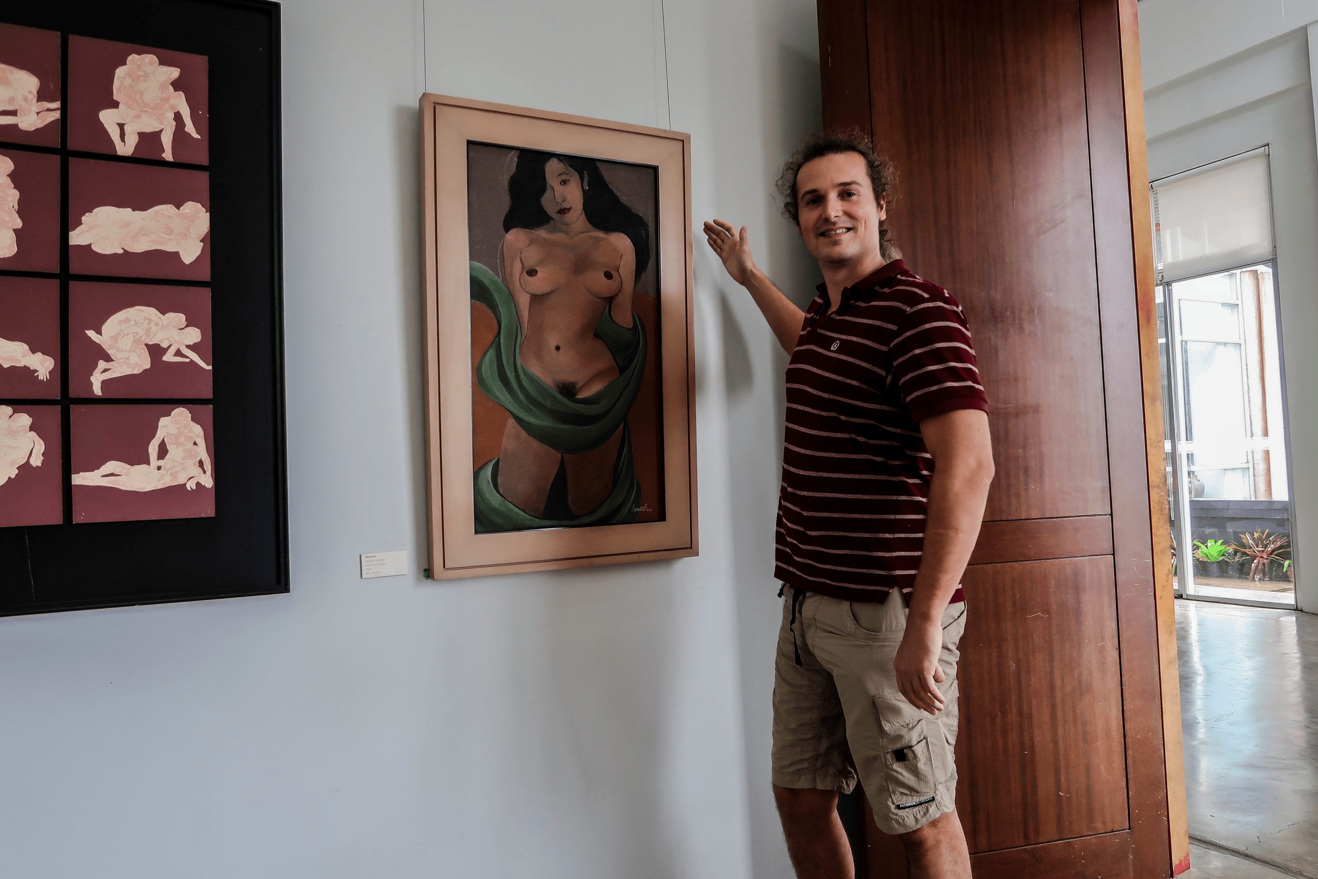 Lennythroughparadise in the bencab museum baguio city philippines at the erotica room, smiling at a painting of a naked filipina woman
